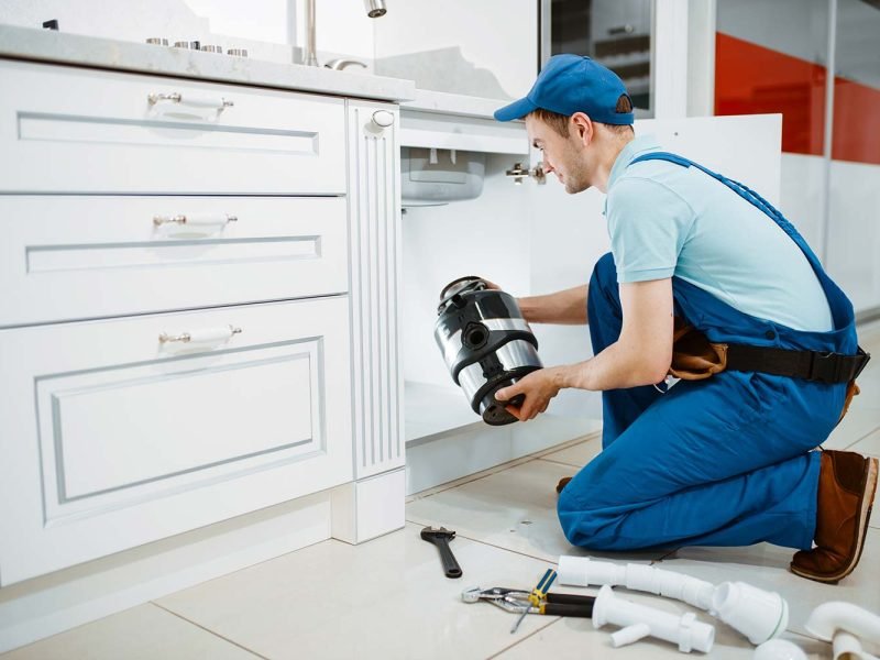 male-plumber-in-uniform-installing-disposer-resize.jpg